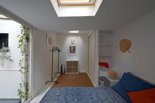 a bedroom with a bed in a room with a ceiling at Studio chez Thomas in Paris