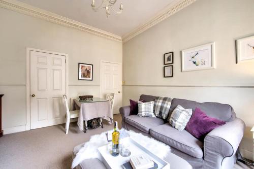 a living room with a couch and a table at ALTIDO Lovely 1 bed flat in Old town, right on the Royal Mile in Edinburgh