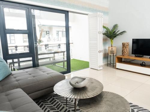 a living room with a couch and a table at Azure 213 - Luxury 2 Bedroom Apartment in Big Bay