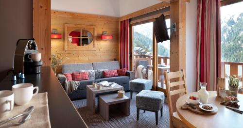 - un salon avec un canapé et une table dans l'établissement Résidence Pierre & Vacances Premium les Crets, à Les Allues