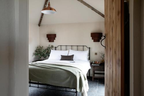 1 dormitorio con 1 cama con sábanas blancas y lámpara en Gate Lodge@White Strand en Miltown Malbay