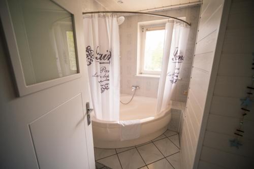 a bathroom with a bath tub and a window at Dom na wzgórzu z widokiem na jezioro z balią i sauną in Lipnica