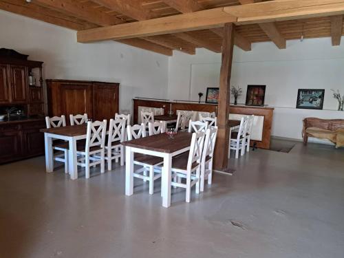 a dining room with a table and white chairs at Tarcal Apartman in Tarcal