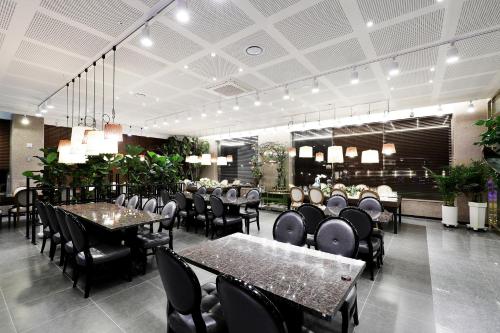 une salle à manger avec des tables et des chaises dans un restaurant dans l'établissement Buan Tourist Hotel, à Buan