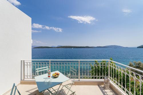 a balcony with a table and a view of the water at Greek Beach House A6 Lefkada in Nydri