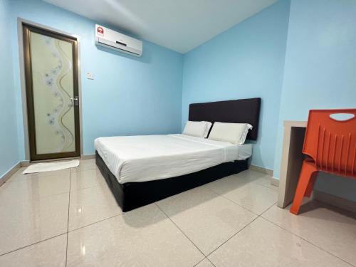 a small bedroom with a bed and a chair at OYO 90789 Stutong Point in Kuching