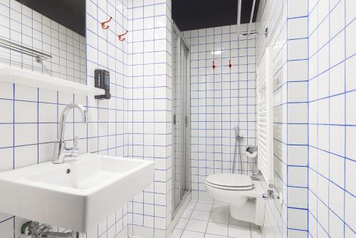 a white bathroom with a sink and a toilet at Generator Rome in Rome