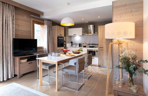 a kitchen with a table and chairs in a room at Résidence Pierre & Vacances Premium L'Hévana in Méribel