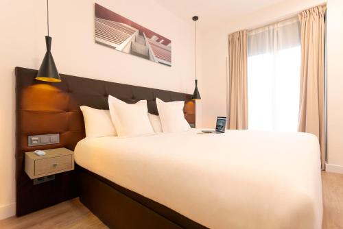 a bedroom with a large bed and a window at Woohoo Rooms Fuencarral in Madrid