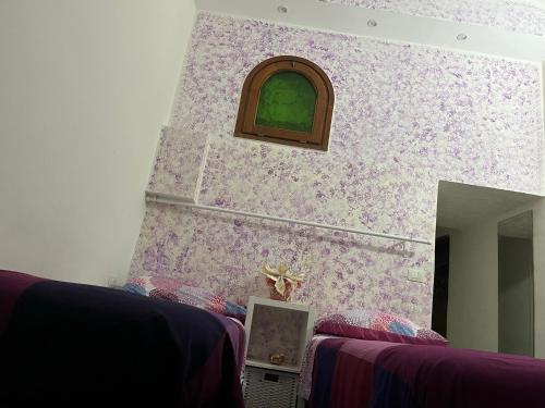 a room with a wall with purple and green wallpaper at Violet 27 in Florence