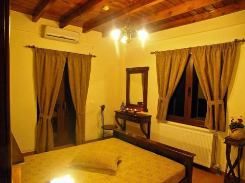 1 dormitorio con cama, mesa y espejo en Kallisti Ξενώνας Διακοπτό-Καλάβρυτα en Diakopto