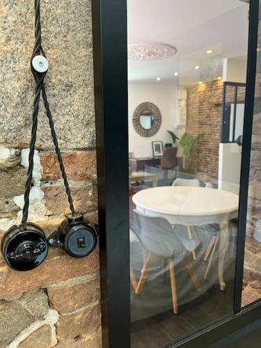 une porte en verre avec une caméra et une table dans une pièce dans l'établissement La bâtisse de Manel, à Cholet