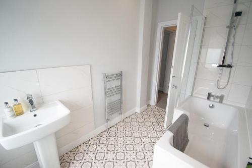 a bathroom with a sink and a tub and a toilet at Ideal Lodgings in Royton in Royton