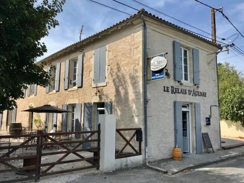 an old building with a wooden fence in front of it at Le Relais D'Aulnay in Aulnay