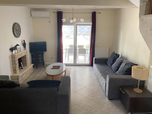 a living room with a couch and a tv at Kalives Sithonia Family house in Kalyves Poligirou