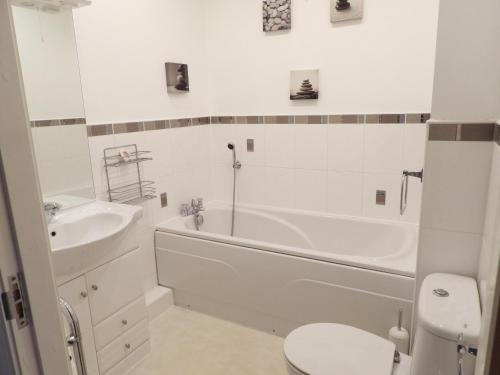 a bathroom with a tub and a sink and a toilet at Beautiful 2-Bed Apartment in Poulton-le-Fylde in Poulton le Fylde