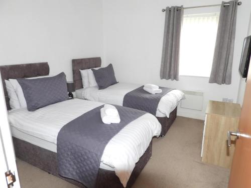 a hotel room with two beds and a window at Beautiful 2-Bed Apartment in Poulton-le-Fylde in Poulton le Fylde