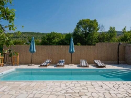 a swimming pool with lounge chairs and umbrellas at Adorable holiday home with swimming pool in Imotski