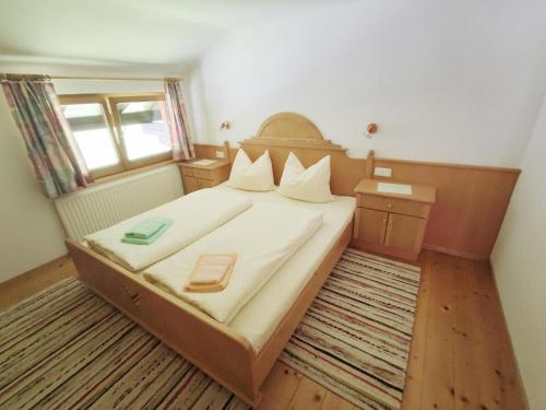 a small bedroom with a large bed with white sheets at Pretty Holiday Home in Mayerhofen with Balcony in Mayrhofen