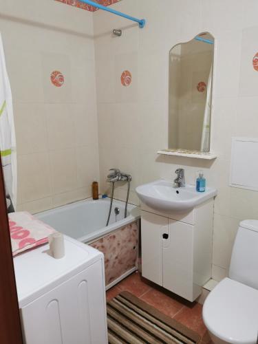 ein Badezimmer mit einem Waschbecken, einer Badewanne und einem WC in der Unterkunft 1 комн квартира в центре in Qostanai