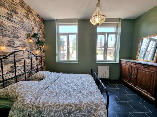 a bedroom with a bed in a room with windows at La Trappiste in Liévin