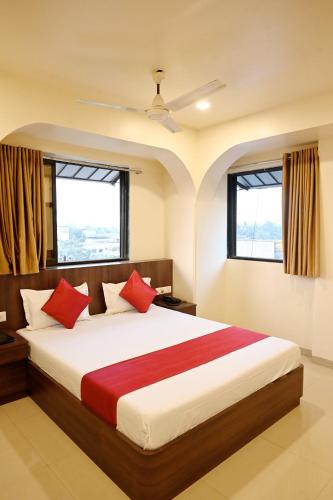 a bedroom with a large bed with red pillows at Hotel Sagar in Kalyan