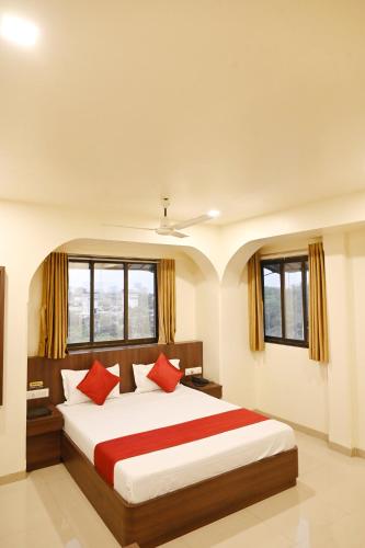 a bedroom with a large bed with red pillows at Hotel Sagar in Kalyan