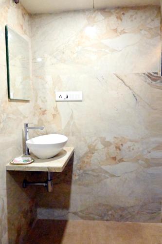 a bathroom with a bowl sink on a counter at Hotel Sagar in Kalyan