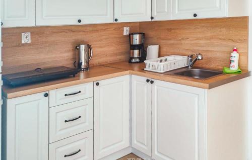 a kitchen with white cabinets and a sink at Nice Apartment In Sarbinowo With Kitchen in Sarbinowo