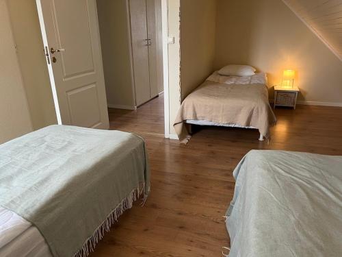 a bedroom with two beds and a wooden floor at Big house, sauna, Wi-Fi, Isaberg, MTB, skiing, golf in Gnosjö