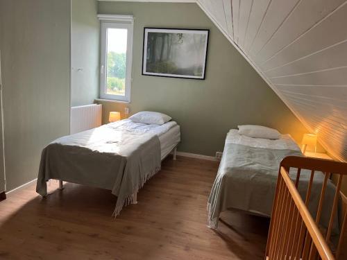 a bedroom with two beds and a stair case at Big house, sauna, Wi-Fi, Isaberg, MTB, skiing, golf in Gnosjö