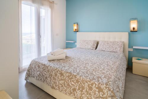 een slaapkamer met een groot bed en een raam bij Pilar Apartment Vista Mare in Portopalo