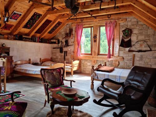 ein Schlafzimmer mit 2 Betten und ein Zimmer mit Stühlen in der Unterkunft Ethno Village Štitarica in Mojkovac