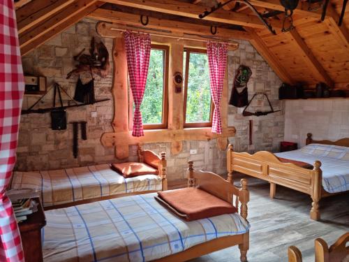 a bedroom with two beds and a window at Ethno Village Štitarica in Mojkovac