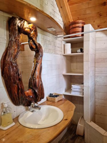 un baño con lavabo con una cabeza de árbol de madera en la pared en Ethno Village Štitarica en Mojkovac