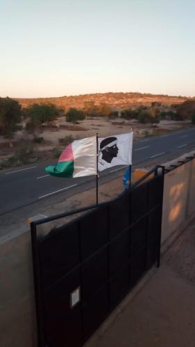 a flag on a fence next to a highway at LE KABOSS in Toliara