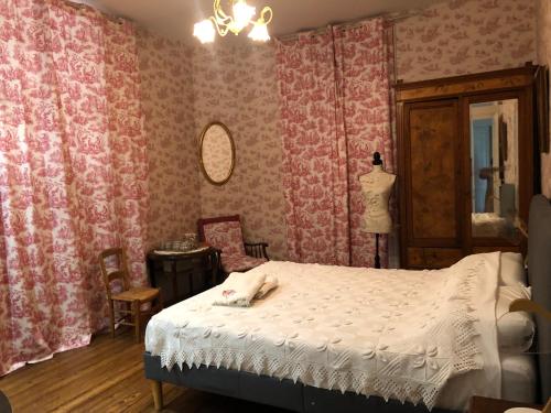 een slaapkamer met roze behang, een bed en een spiegel bij Villa Rhôna in Andancette