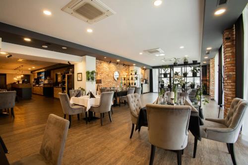 un ristorante con tavoli e sedie e un muro di mattoni di Hotel Scout a Częstochowa