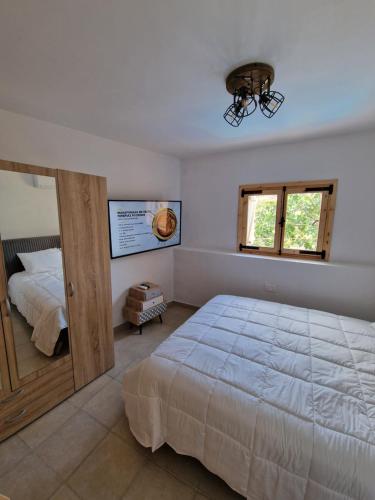 a bedroom with a large bed and a window at Aprosmeno Jacuzzi House 3 With Private Pool in Agros