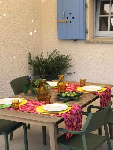 a wooden table with plates and fruit on it at STAZZU LU CHISSONI in Luogosanto