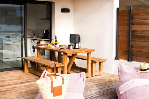 een woonkamer met een houten tafel en een keuken bij Résidence Le Lonca PORTICCIO in Porticcio