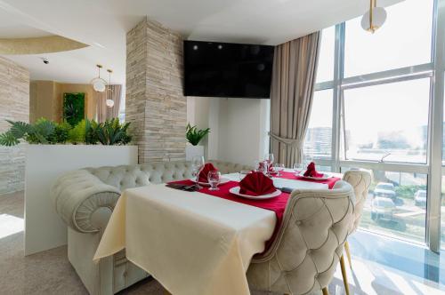 Hotel IDEAL Deluxe في نوفي بازار: غرفة طعام مع طاولة وكراسي وتلفزيون