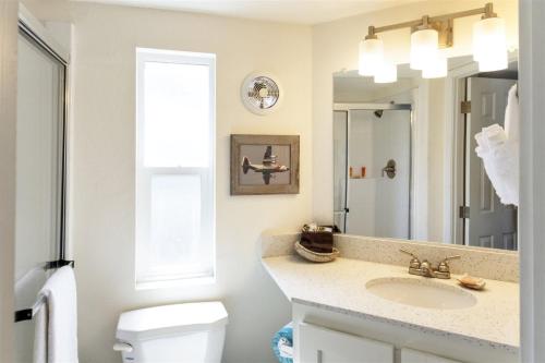 uma casa de banho com um lavatório, um WC e um espelho. em H - Cochito em Fort Bragg