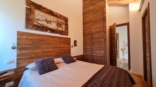 ein Schlafzimmer mit einem Bett mit einer Holzwand in der Unterkunft Masetto in Madonna di Campiglio
