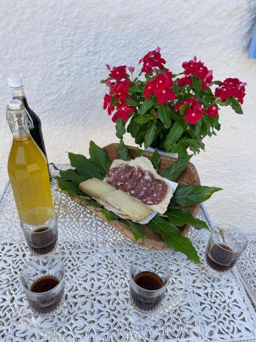 a table with a bottle of wine and red flowers at STAZZU LU CHISSONI in Luogosanto