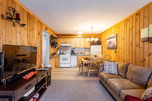 a living room with a couch and a kitchen at Mountainside Haven - walk to Hunter Mtn! in Hunter
