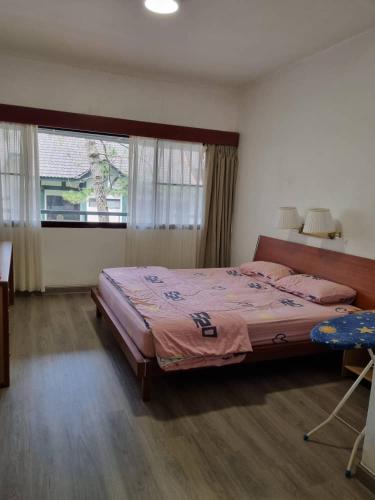 a bedroom with a large bed and a window at Copthorn Homestay in Brinchang