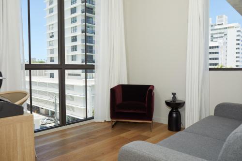 a living room with a couch and a chair and a large window at Uma House by Yurbban South Beach in Miami Beach