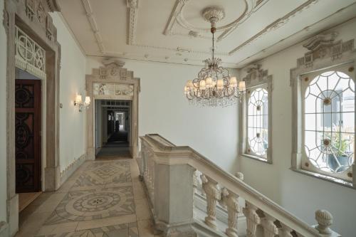 un couloir avec un lustre et des escaliers dans un bâtiment dans l'établissement Octant Lousa, à Lousã