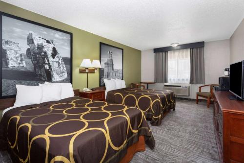 Habitación de hotel con 2 camas y TV de pantalla plana. en Super 8 by Wyndham Amarillo Central TX, en Amarillo